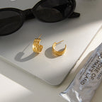 side view of stainless steel wide hoop earrings with botanical relief