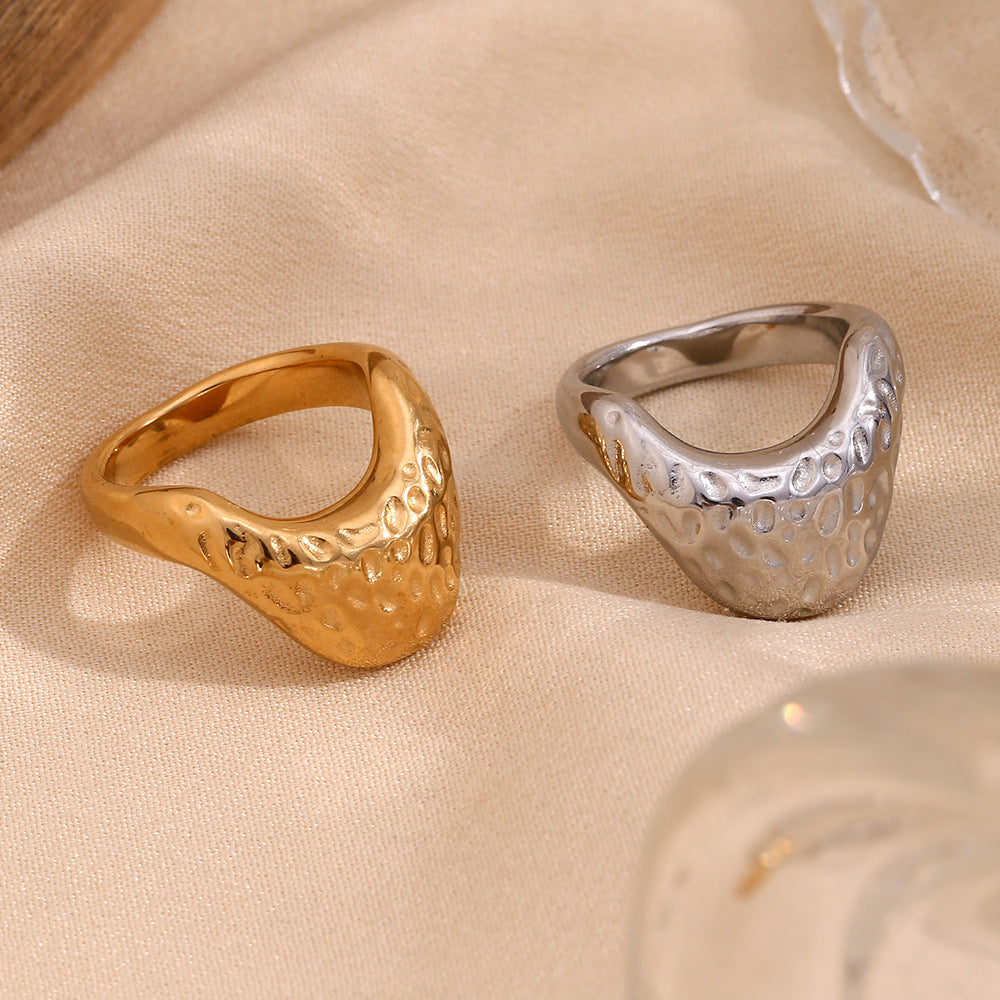 gold and silver stainless steel signet rings on neutral fabric