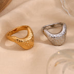 gold and silver stainless steel signet rings on neutral fabric