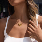 Gold tone wave necklace worn at the neckline