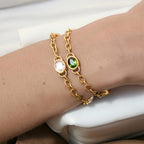 Green and clear oval-stone bracelets worn together