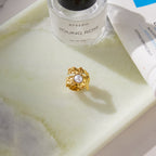 Round pearl-look accent against irregular metal texture