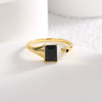 rectangular black stone open ring displayed on a white block
