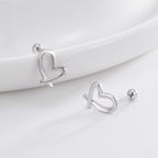 silver ribbon-heart earrings displayed on a curved white surface