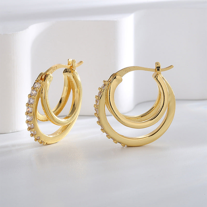gold plated triple hoop clear stone earrings in an upright studio view