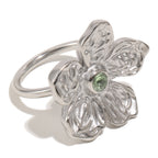 isolated silver-finish stainless steel flower ring with green center stone