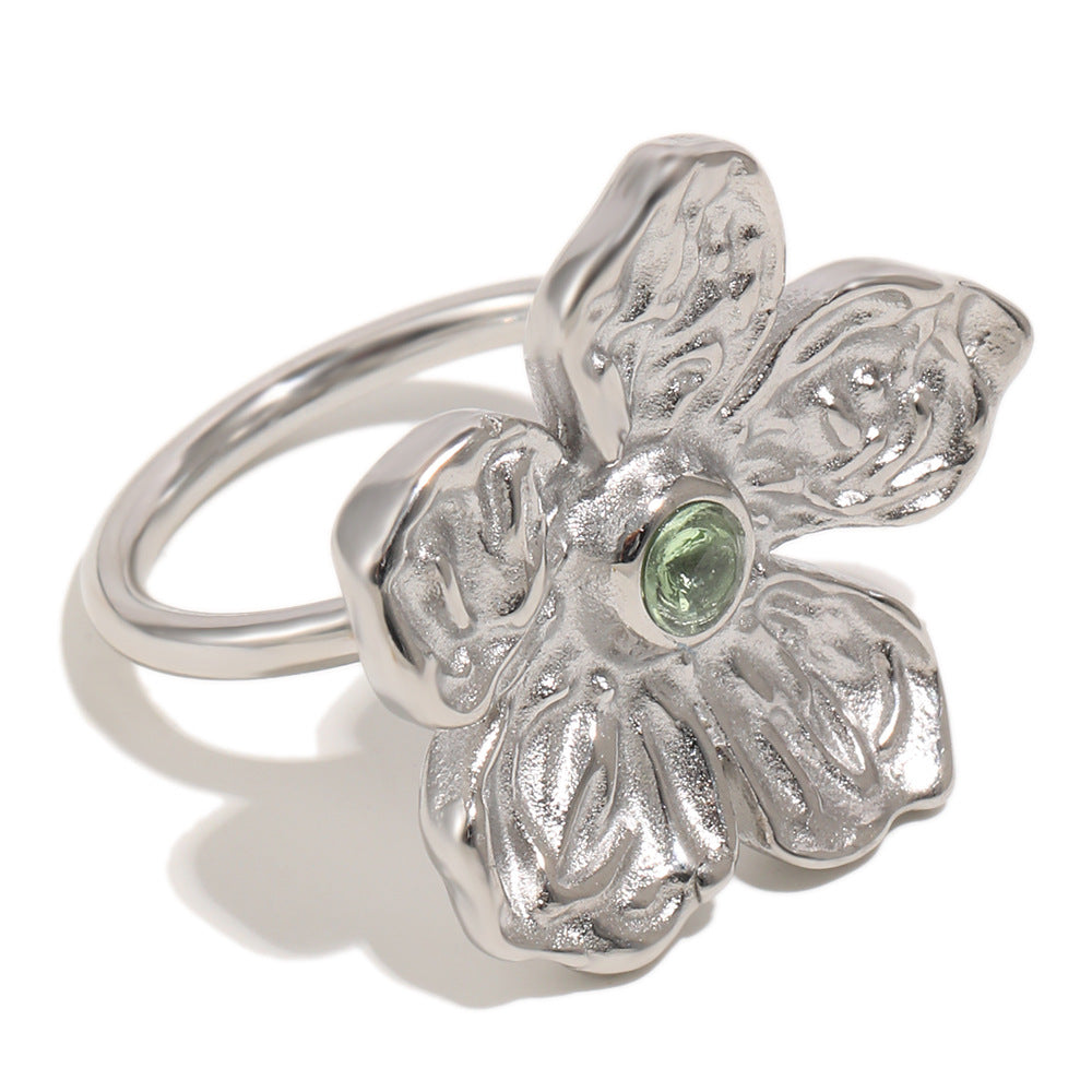 isolated silver-finish stainless steel flower ring with green center stone