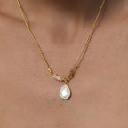 Pear halo necklace worn at the neckline