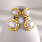 pair of gold plated imitation pearl drops on a curved white display