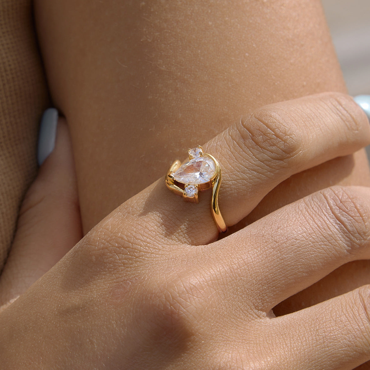 Side view of gold-tone bypass ring worn close-up
