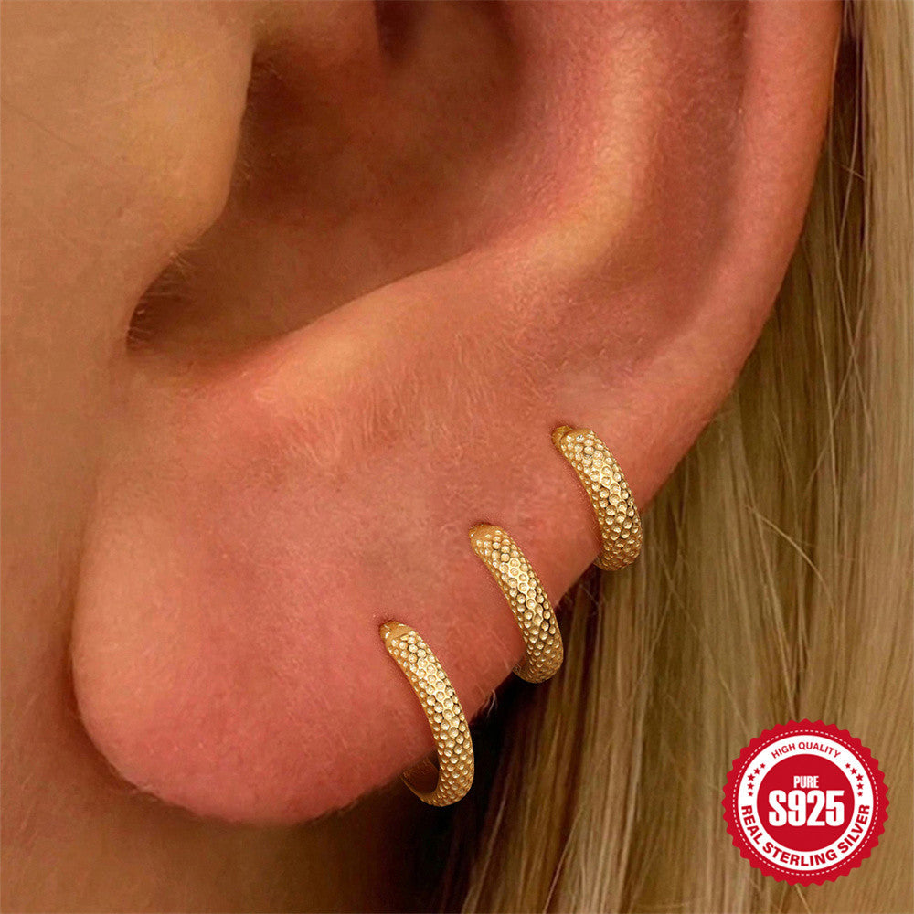 6 mm, 8 mm and 10 mm textured gold huggies worn as an ear stack