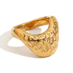 isolated gold plated stainless steel signet ring with pebble texture