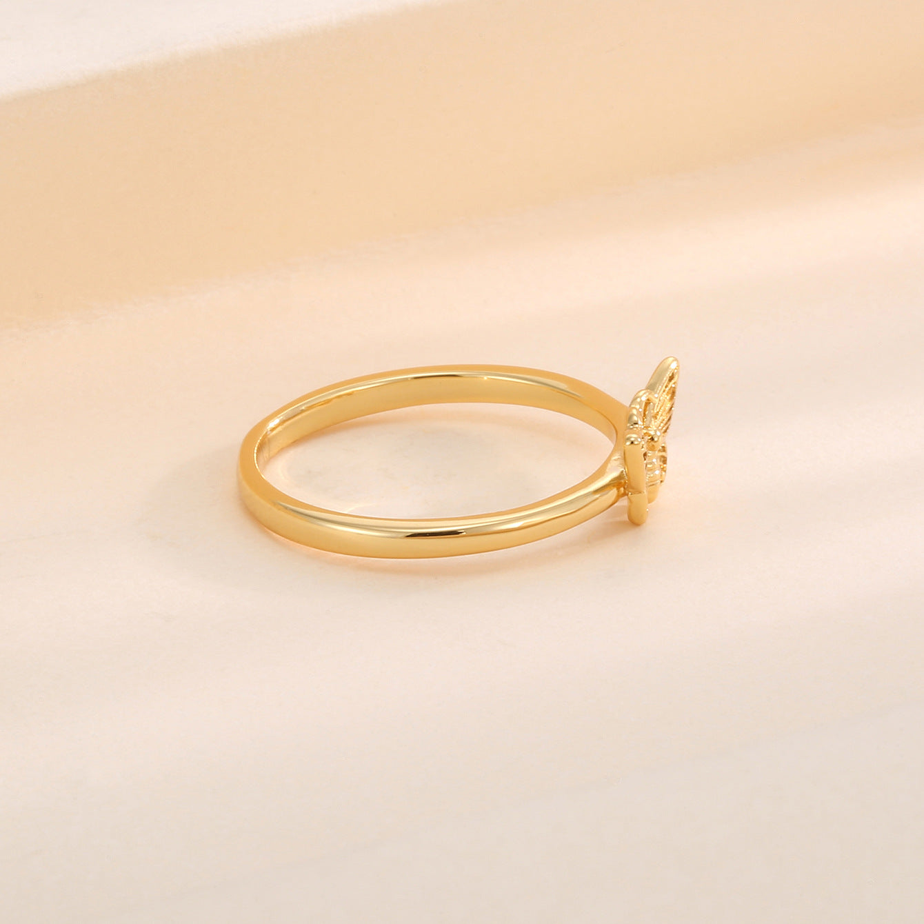 side profile of engraved butterfly centerpiece on gold plated ring