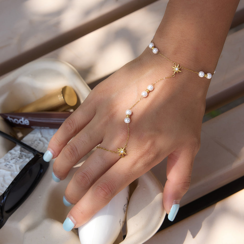 Pearl hand chain with starburst connector worn on a model
