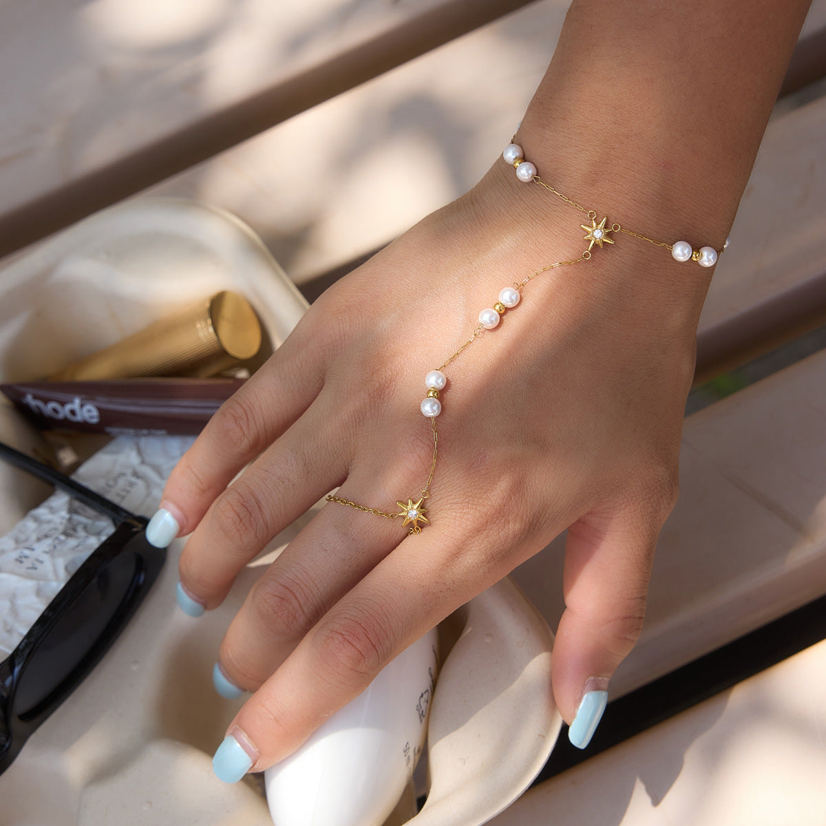 Pearl hand chain with starburst connector worn on a model