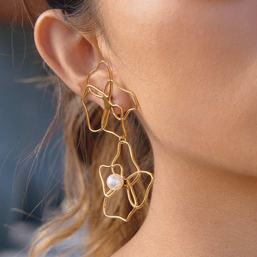 gold plated open floral pearl-style drop earring worn on ear