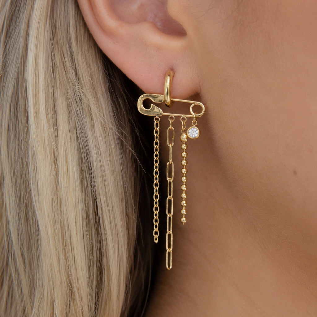 Long chain tassel earring with horizontal pin motif worn on an ear