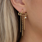 Long chain tassel earring with horizontal pin motif worn on an ear