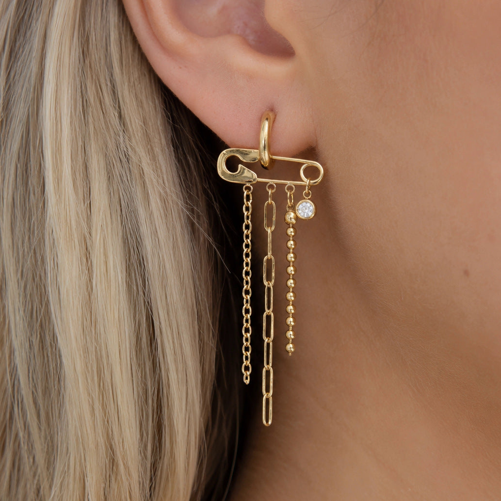 Long chain tassel earring with horizontal pin motif worn on an ear