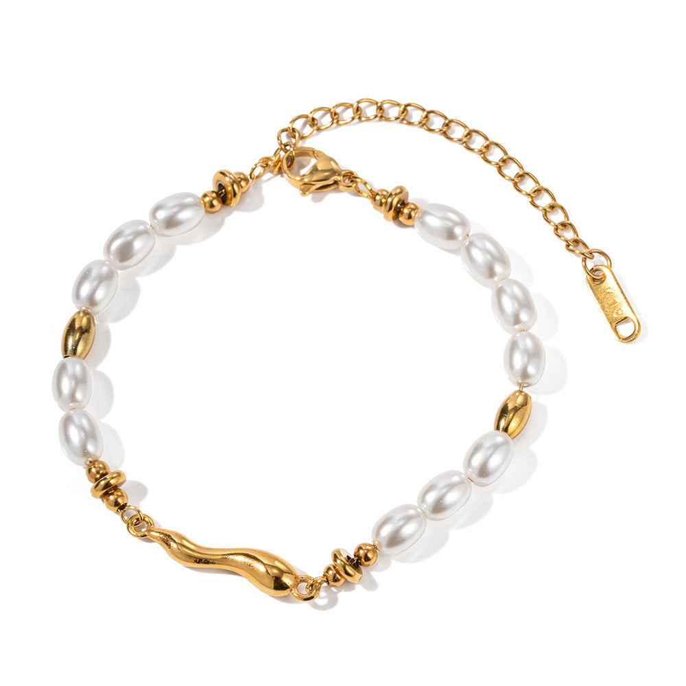 isolated gold plated bracelet with white oval beads and irregular center link
