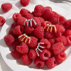 Gold and steel color stud earrings on raspberries