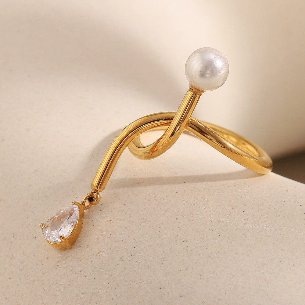side view of asymmetrical knotted open ring with clear stone drop