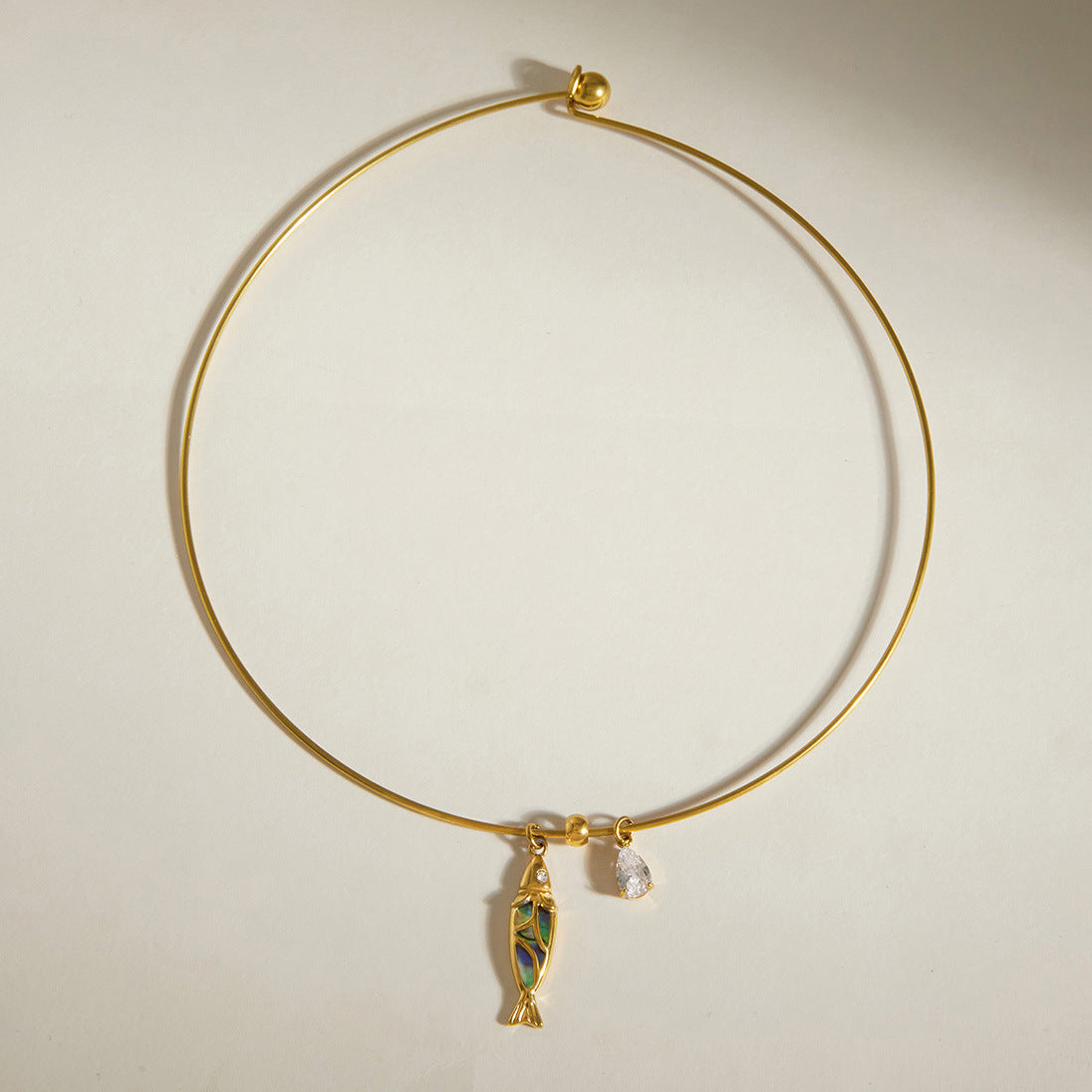 Gold-tone collar with multicolor inlay fish charm and clear drop