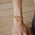 Triangle link bracelet worn beside a tennis bracelet