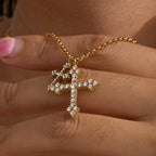 Double clear-accent cross pendant held close-up