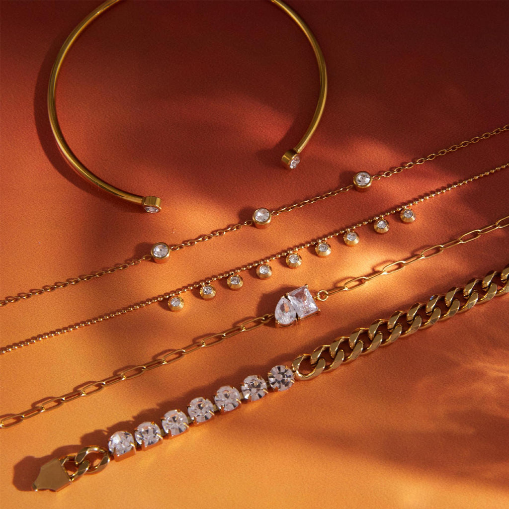 Clear-stone chain and cuff selection on a red background
