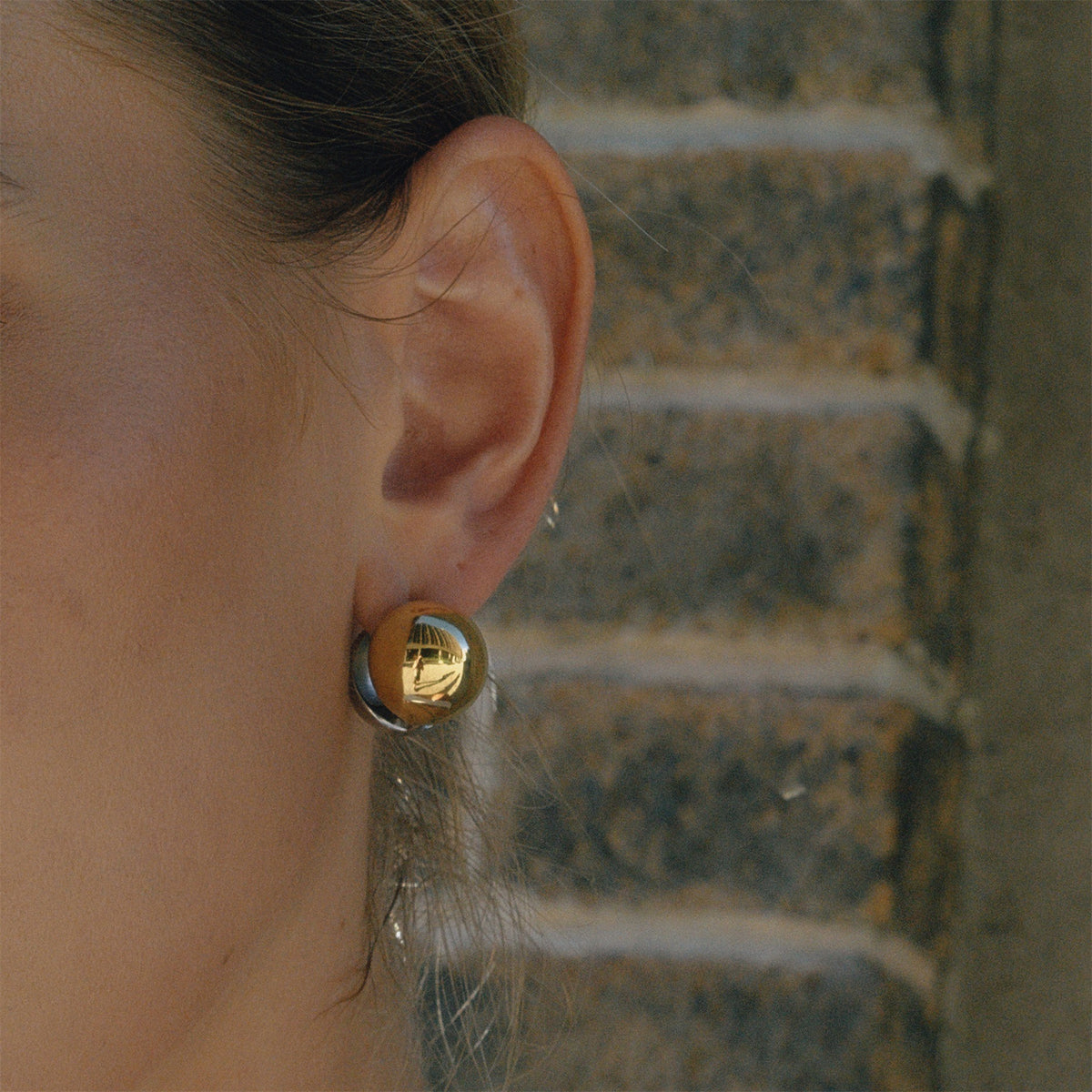 Two-Tone Half-Dome Stainless Steel Stud Earrings shown on model