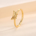 angled butterfly motif ring on a warm cream background