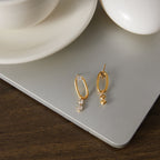 Pair of oval link earrings displayed on neutral board