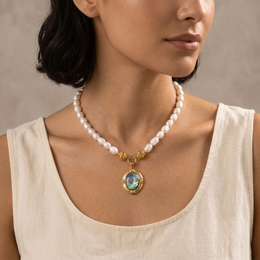white beads necklace with oval iridescent pendant worn on model