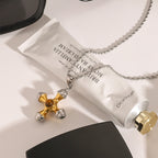 Gold and silver-colored cross necklace styled beside a tube