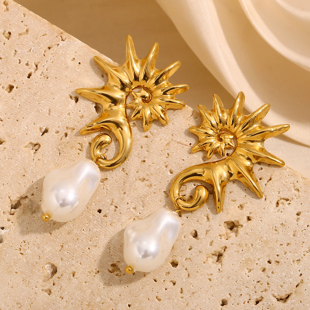 angled pair of gold plated seahorse and pearl drop earrings