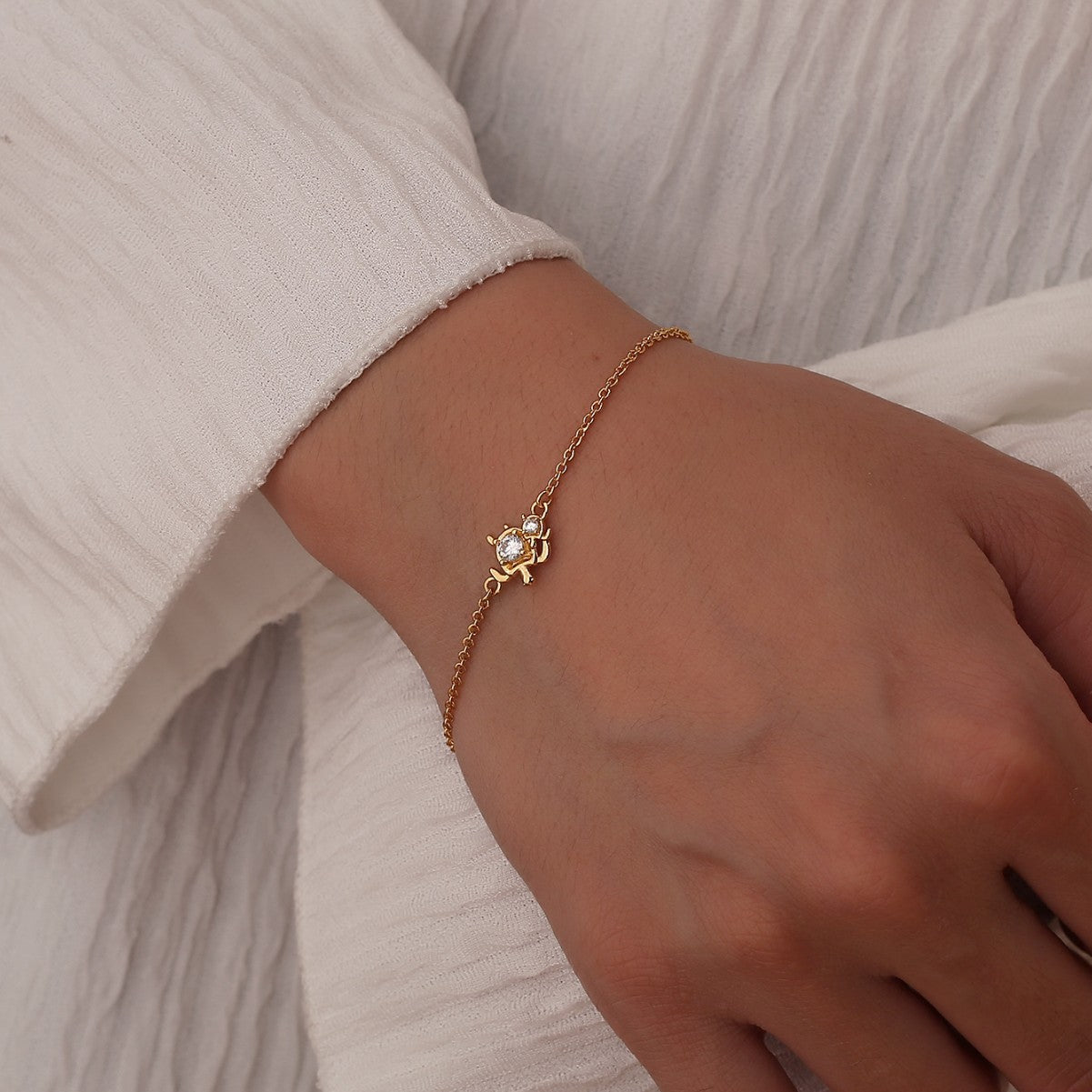 model wearing a fine gold plated turtle chain bracelet
