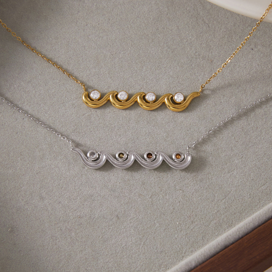 Front of gold tone wave necklace and reverse of silver tone version