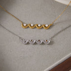 Front of gold tone wave necklace and reverse of silver tone version
