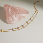 Double-chain bracelet with pink and clear stones laid flat