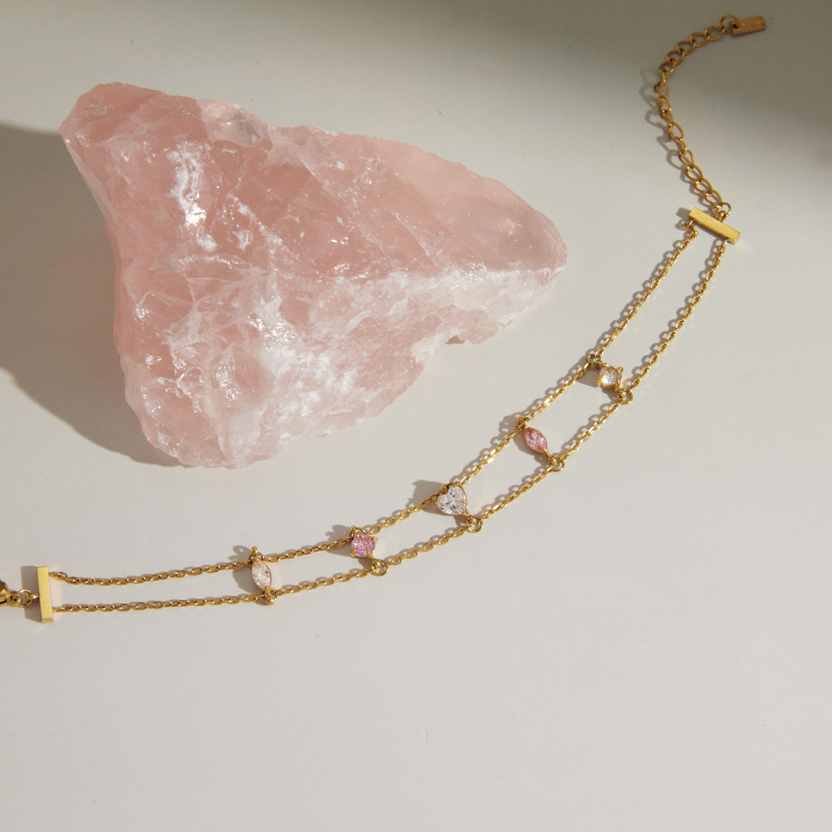 Double-chain bracelet with pink and clear stones laid flat