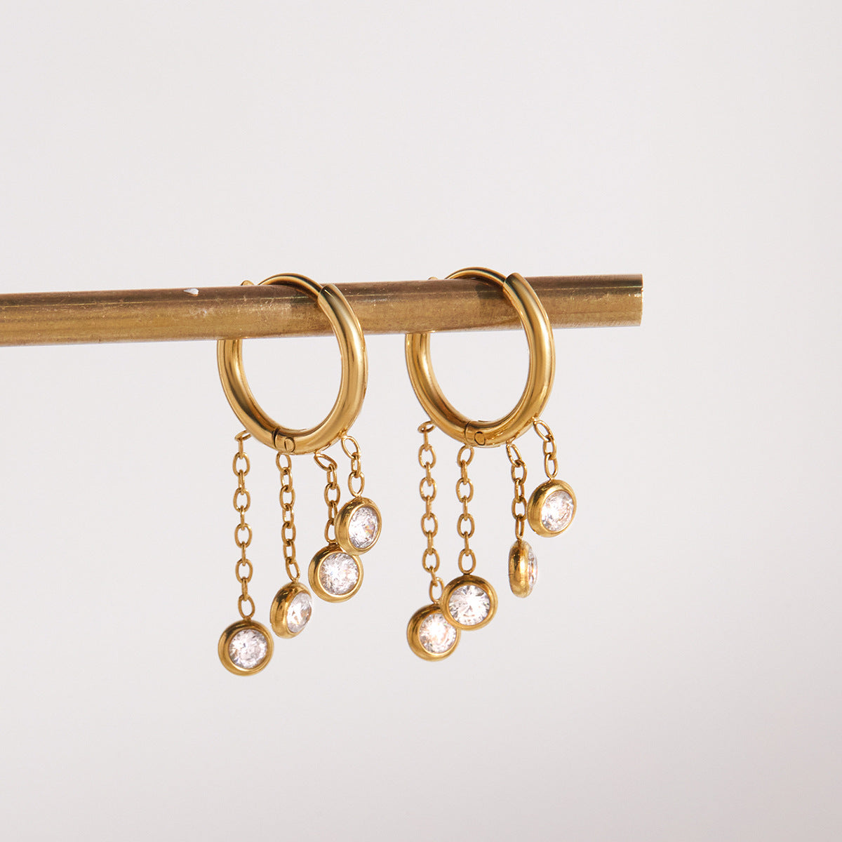 pair of stainless steel hoops with three fine chain drops