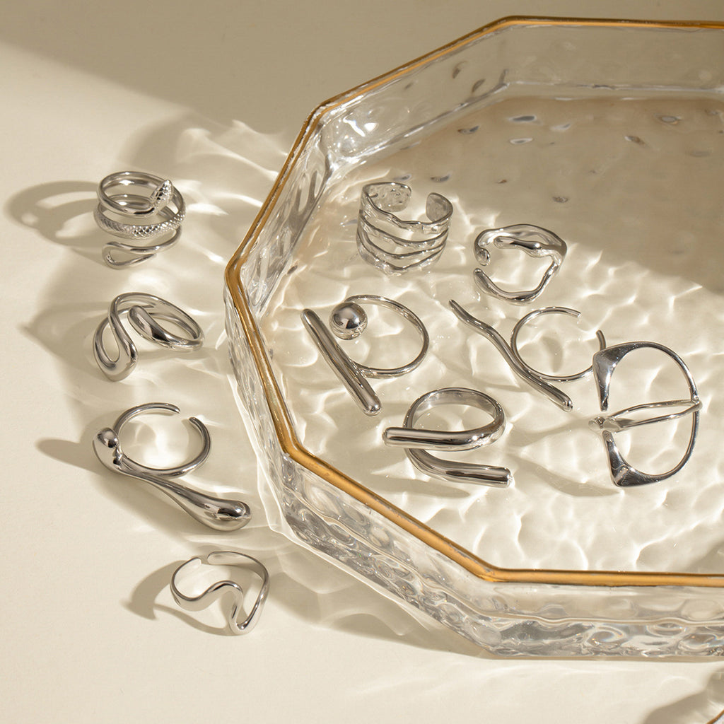 Silver stainless steel sculptural ring collection styled on glass