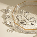 Silver stainless steel sculptural ring collection styled on glass