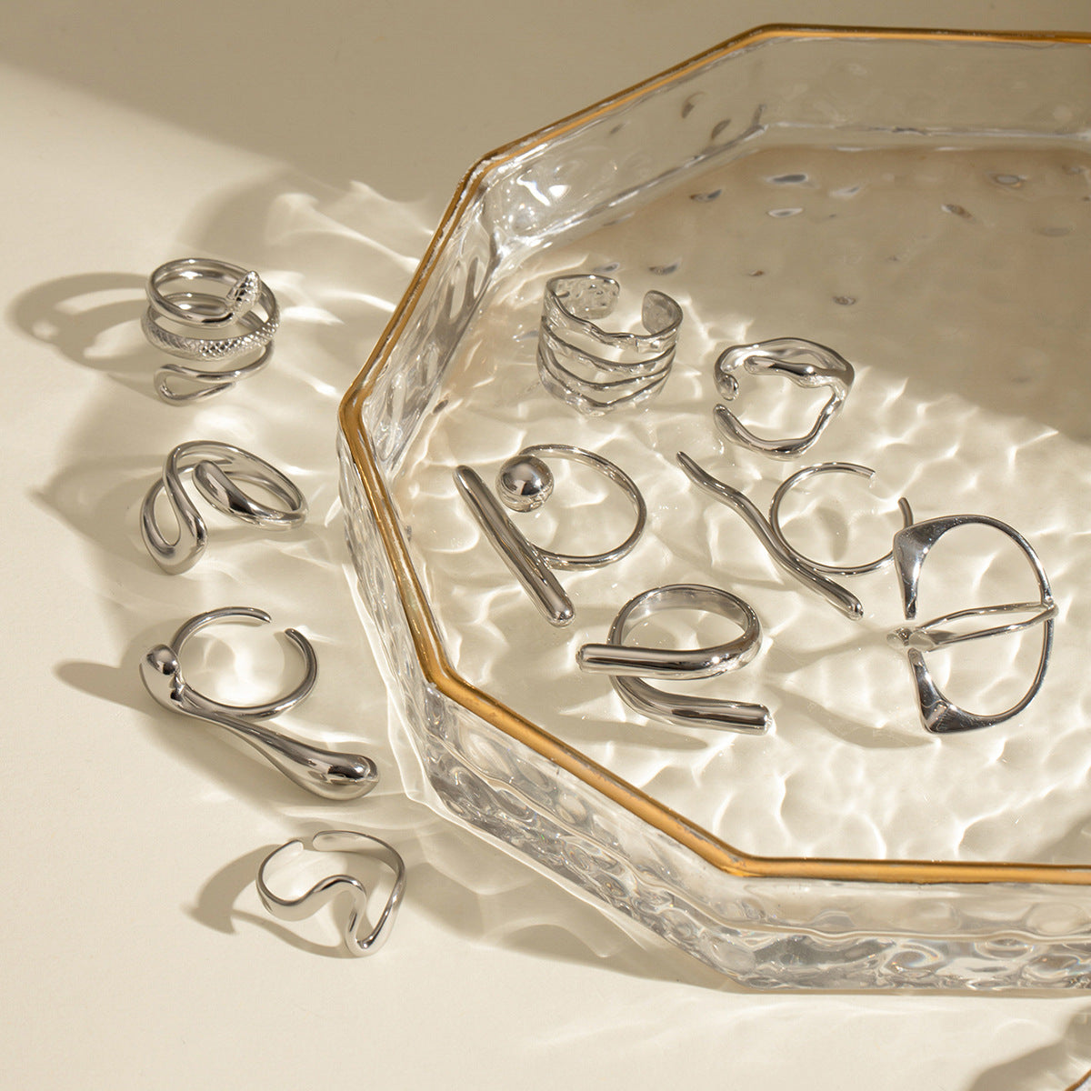 Silver stainless steel sculptural ring collection styled on glass
