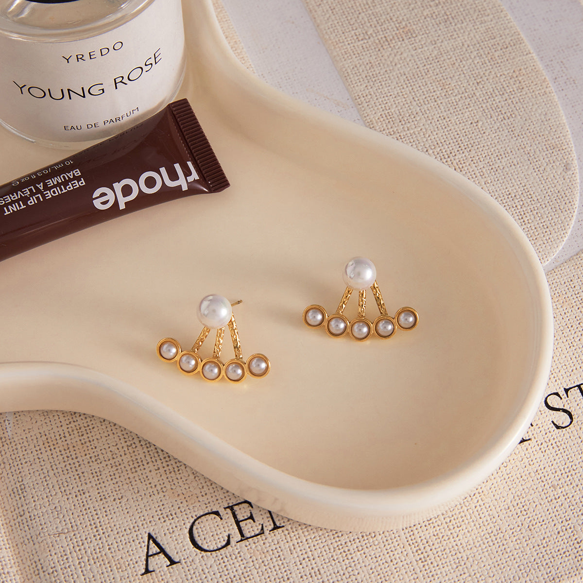 Gold-tone pearl stud earrings styled pair