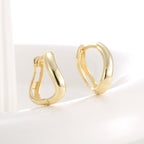 polished asymmetric huggie earrings in three-quarter view