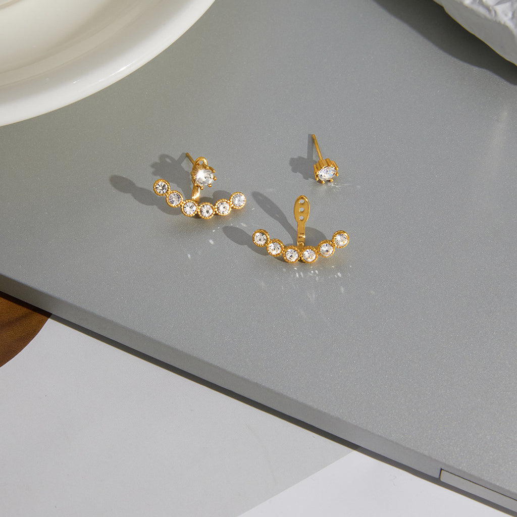 pair of clear stone ear jacket earrings on gray surface