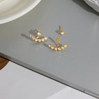 pair of clear stone ear jacket earrings on gray surface