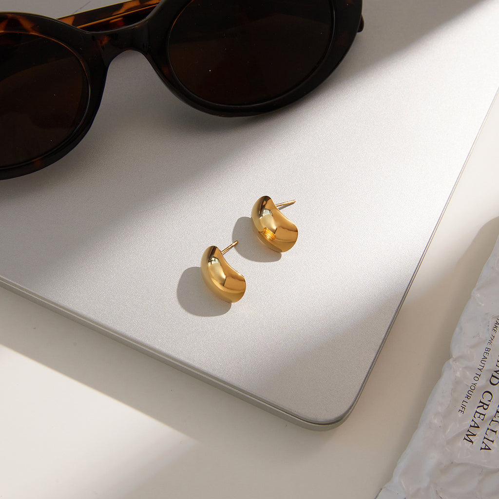 gold plated rounded dome earrings beside sunglasses